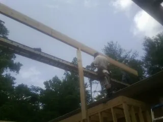 Carpenter setting a ridge beam over a new addition frame — Ice Dam Removal by Roofing Brothers in Morse Bluff
