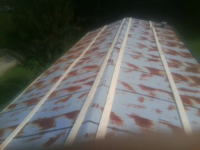 Rusted metal roof panels with new wood purlins before replacement — Storm Damage Roof Repair in Morse Bluff by Roofing Brothers